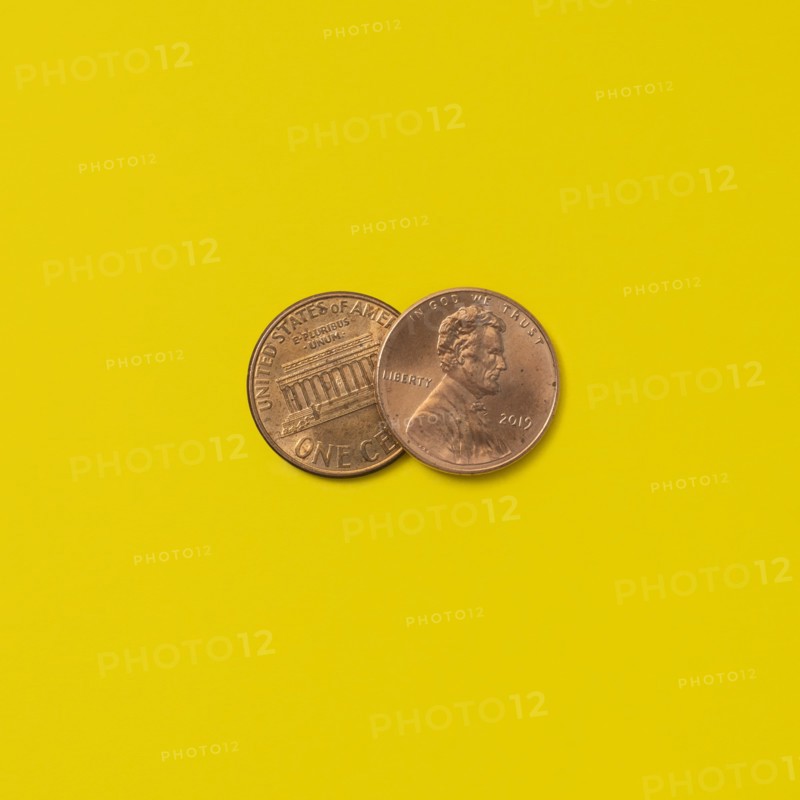 Front and back of two pennies on yellow background