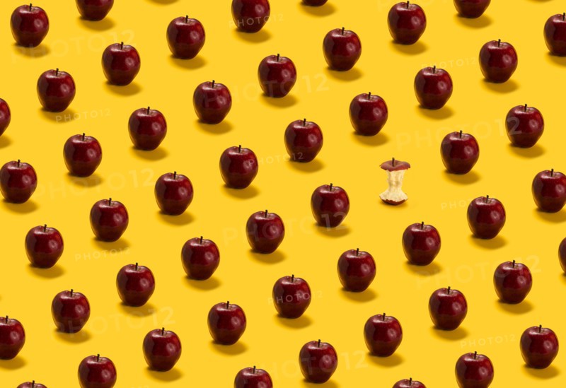 Large group of red apples on yellow background