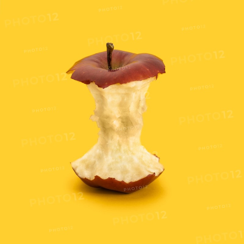 Core of red apple against yellow background