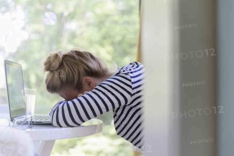 Woman using laptop and falling asleep
