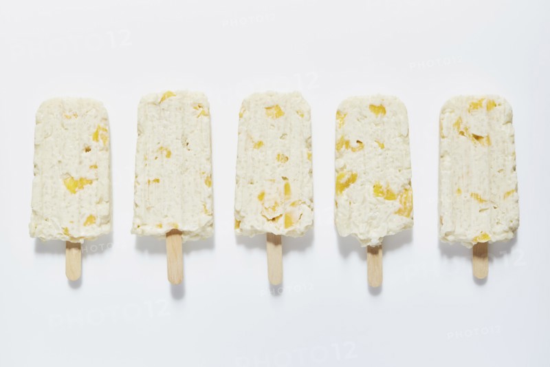 Rice and mango popsicle sticks on white background