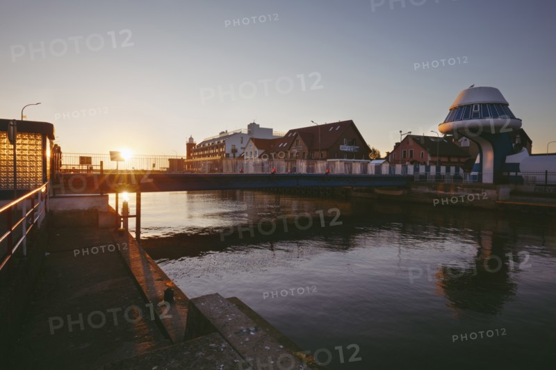 Poland, West Pomerania, Darlowek, Lighthouse and bridge over Wieprza River at sunset