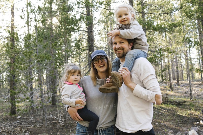 Portrait of happy parents carrying little daughters