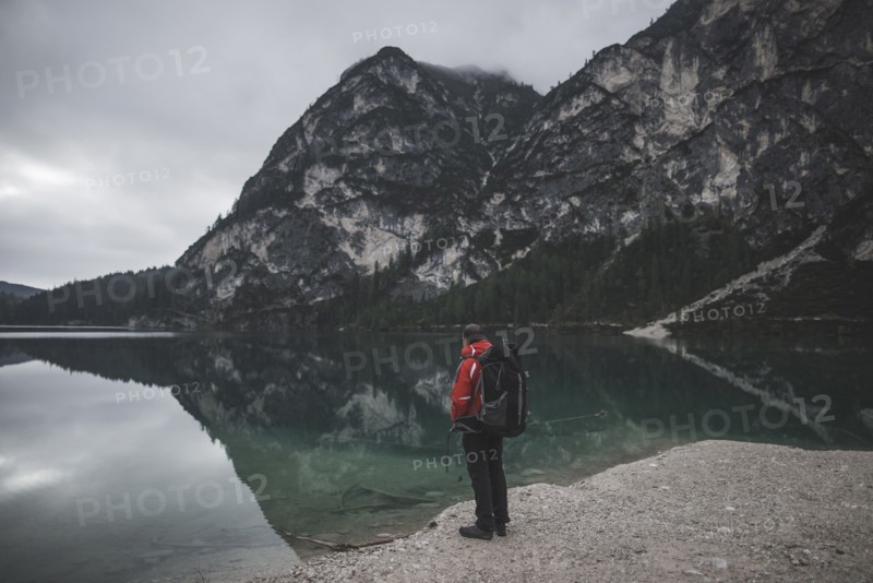 Italy, Pragser Wildsee, Dolomites, South Tyrol, Man looking at view standing near mountain lake