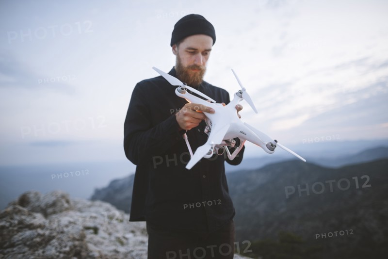 Italy, Liguria, La Spezia, Man at mountain top holding drone