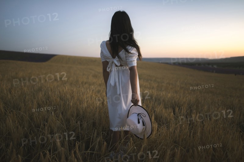 France, Woman in white dress standing in field