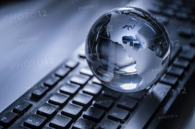 Glass globe on computer keyboard