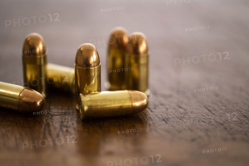 Gold bullets on wooden surface