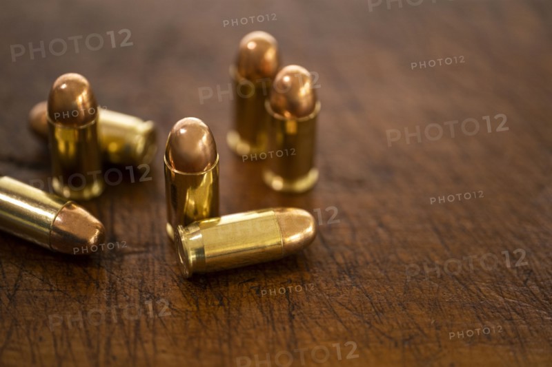 Gold bullets on wooden surface