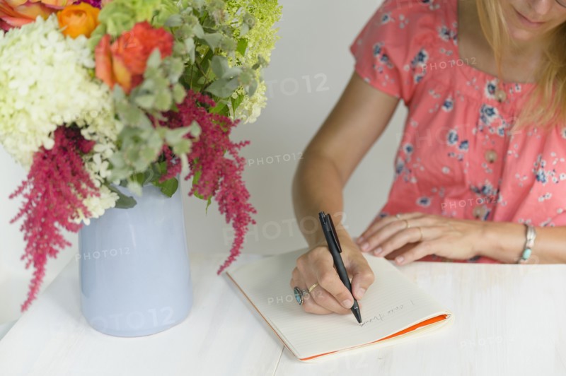 Woman writing in notepad