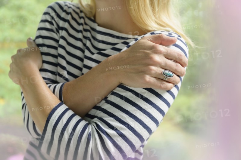 Close-up of blond woman hugging herself