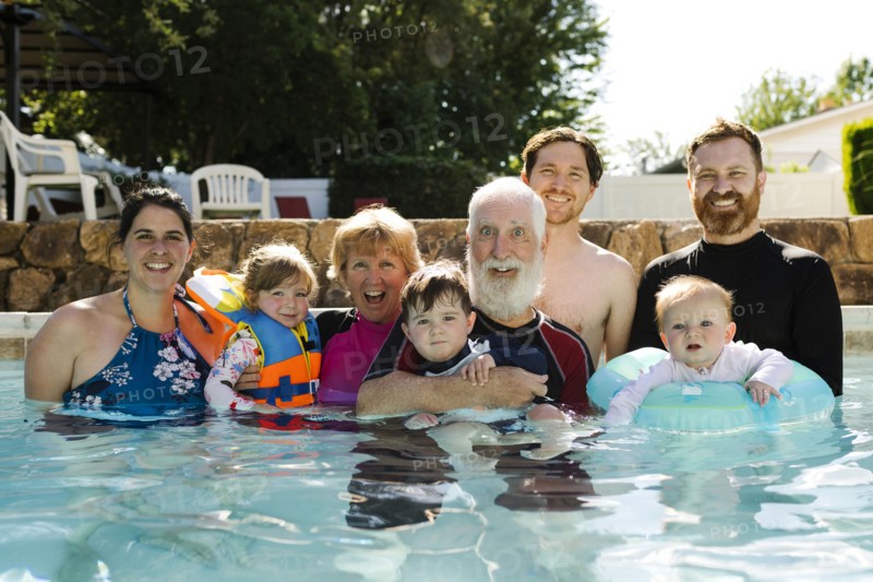 Portrait of multigeneration family posing in swimming pool
