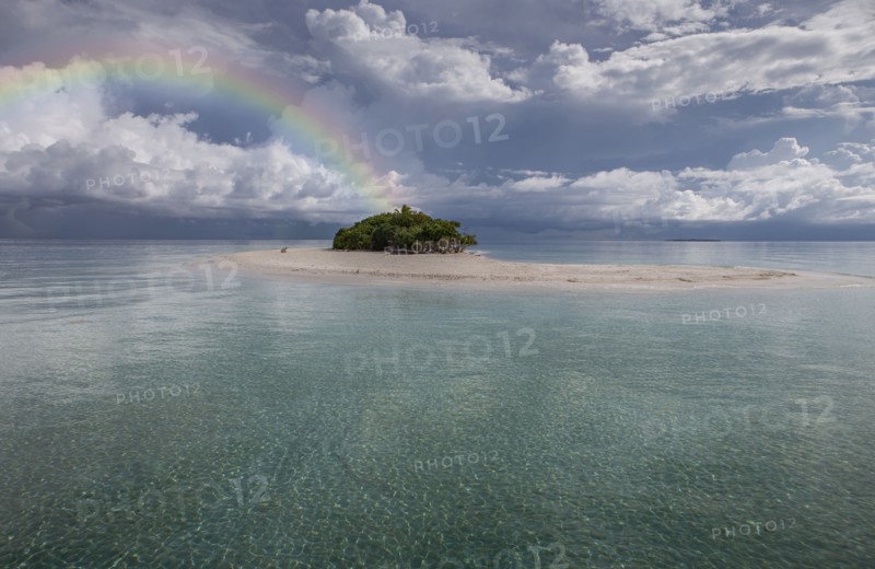Maldives, Rainbow over small tropical island on calm sea