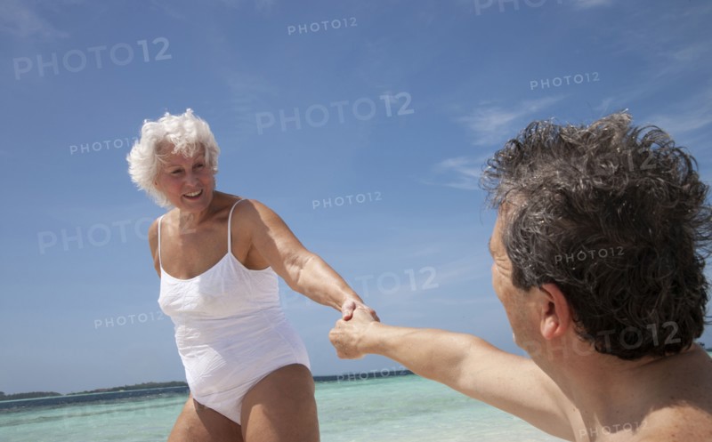 Indian Ocean, Maldives, Ari Atoll, Vilamendhoo Island, Happy couple holding hands on tropical beach