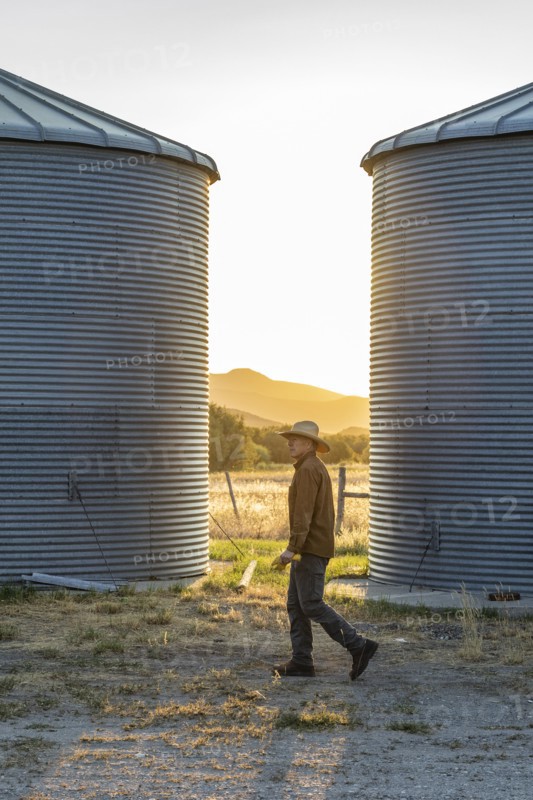 USA, Idaho, Bellevue, Rancher walking past silos