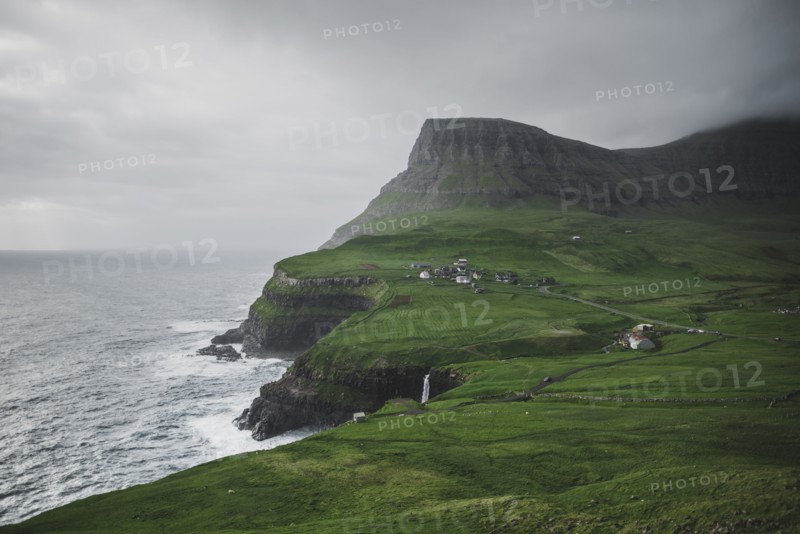 Denmark, Faroe Islands, Gasadalur village, Mulafossur Waterfall, Cliffed coast and ocean