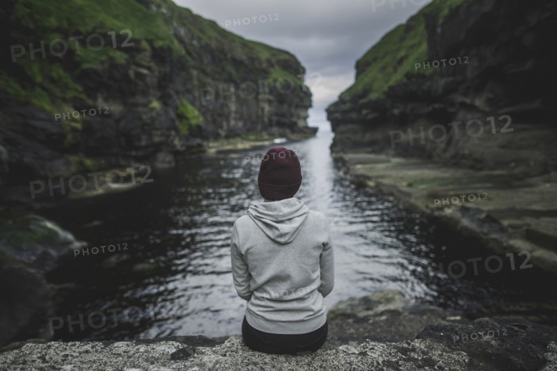 Denmark, Faroe Islands, Gjgv, Woman sitting in gorge