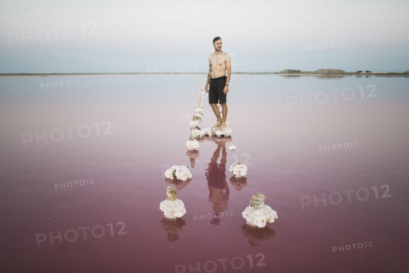 Ukraine, Crimea, Man standing on salt crystal in salt lake