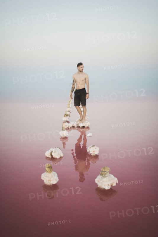 Ukraine, Crimea, Man standing on salt crystal in salt lake
