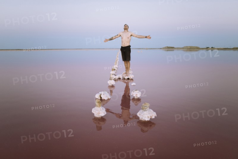 Ukraine, Crimea, Man standing on salt crystal in salt lake