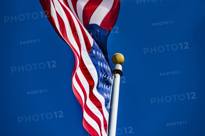 American flag blowing in wind against blue sky