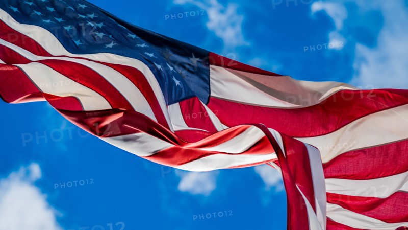 American flag blowing in wind against sky