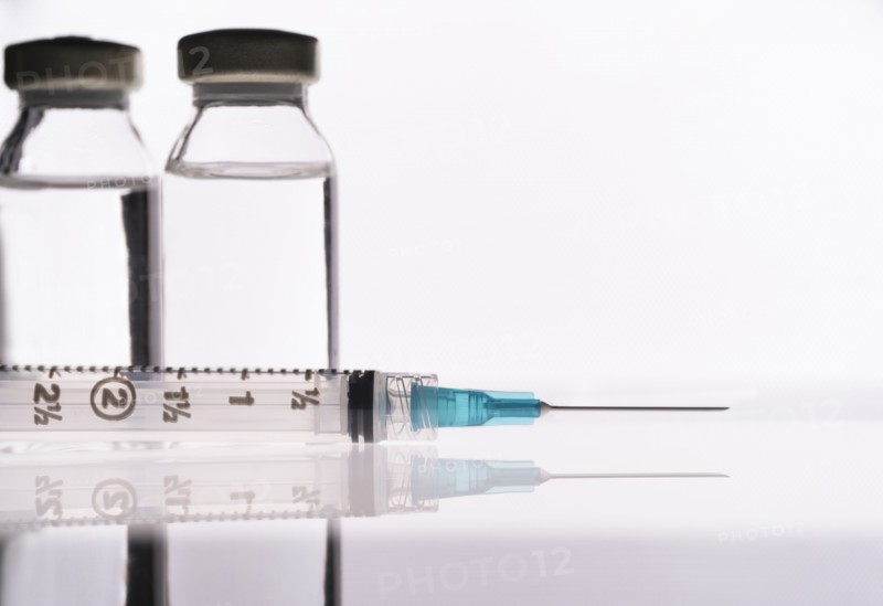 Studio shot of Covid-19 vaccine and syringe