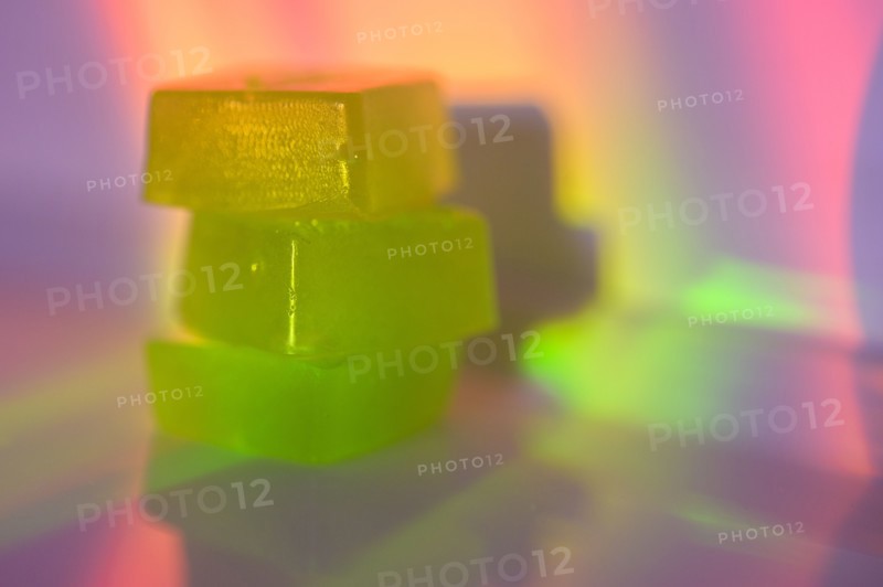 Stack of edible cannabis gummies in rainbow light