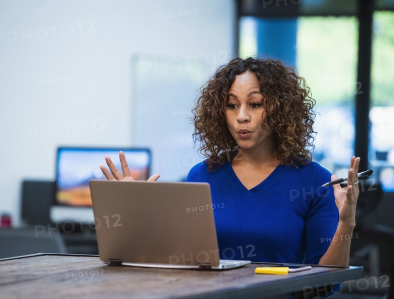 Woman looking at laptop at desk in office