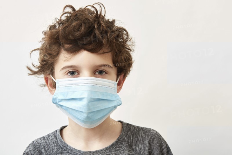 Boy (8-9) wearing protective face mask