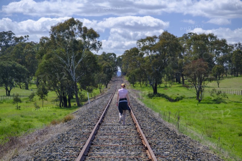 Woman hiking along railroad track