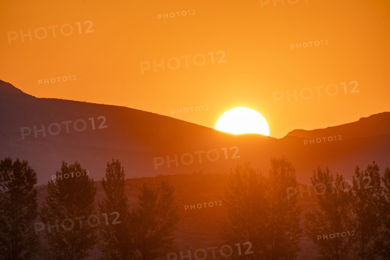 Sun rising behind mountain