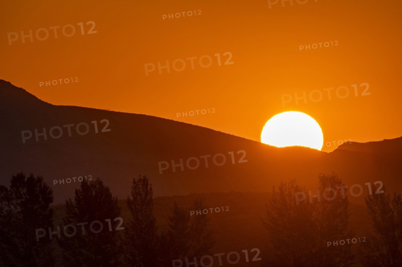 Sun rising behind mountain