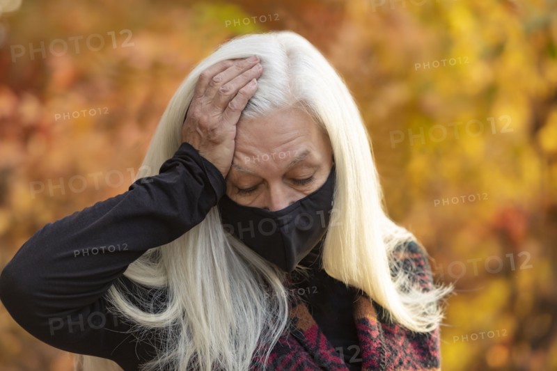 Portrait of senior woman wearing Covid protective mask outdoors in fall