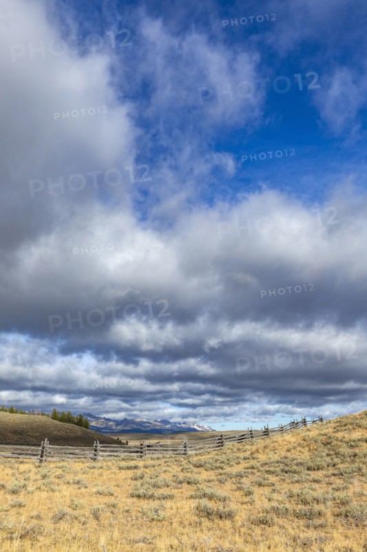 Ranch landscape with clouds and mountains in distance