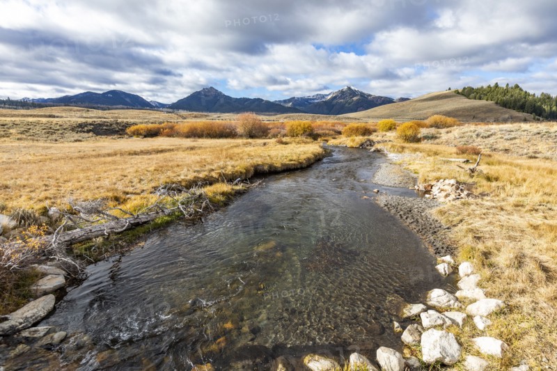 Landscape with stream and mountains in distance