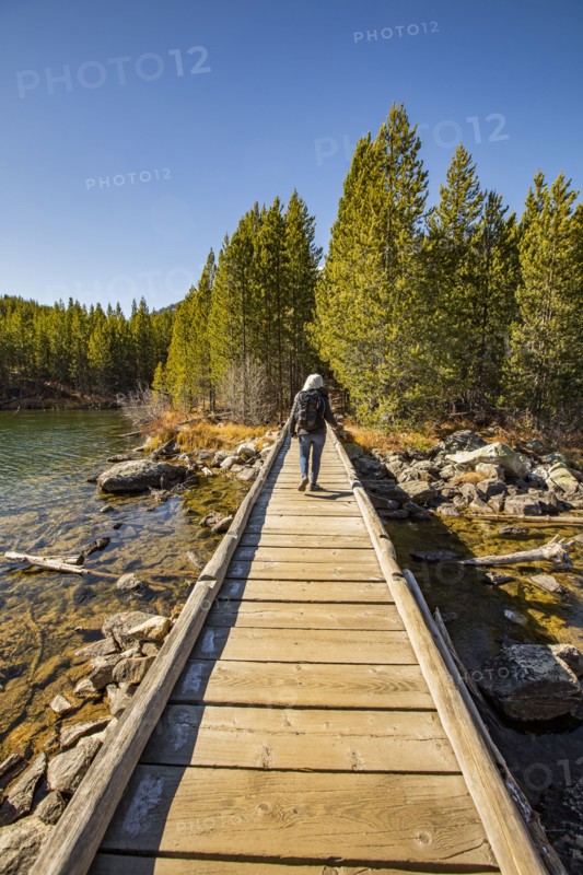 Senior woman walking on wooden path over Taggart Lake in Grand Teton National Park