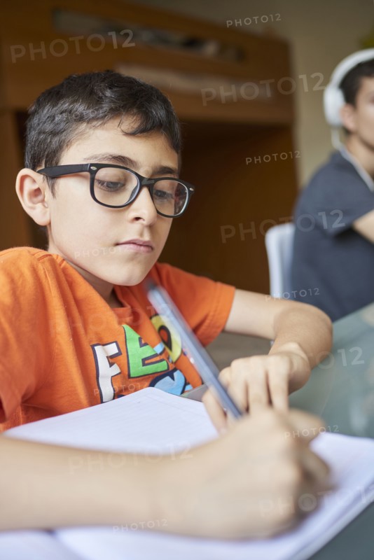 Two boys learning at desk at home during Covid-19 lockdown