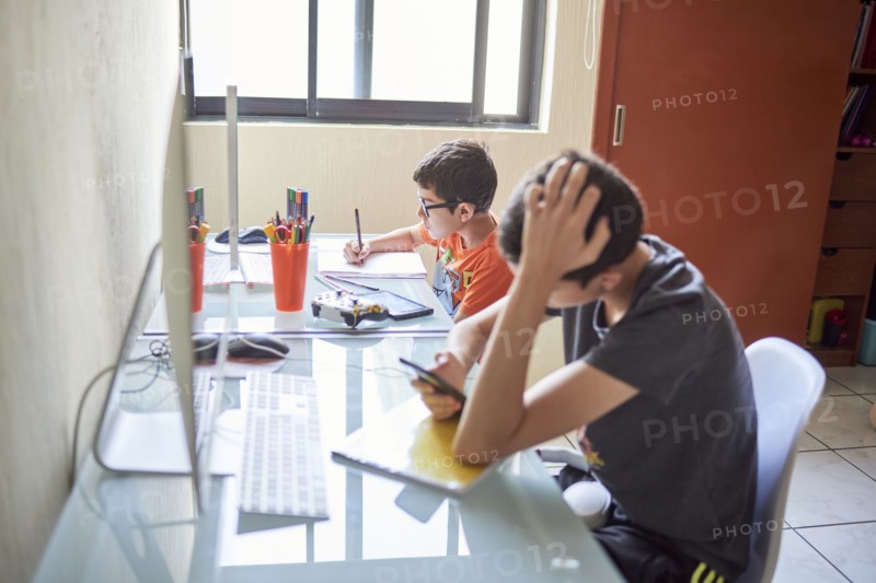 Two boys learning at desk at home during Covid-19 lockdown