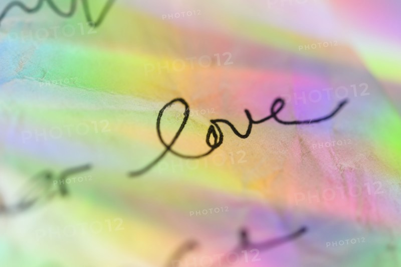 Handwriting on paper with colorful reflections
