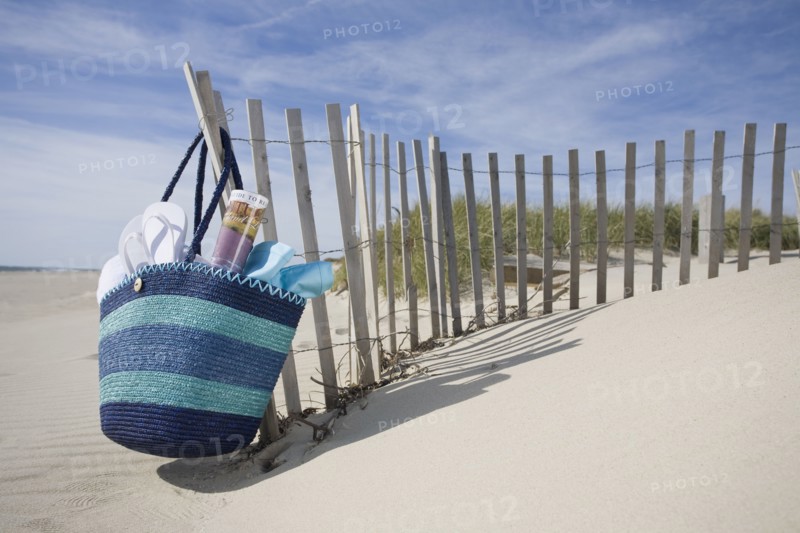 Beach bag with flip-flops on beach