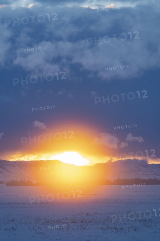 Sun setting over mountains and prairie