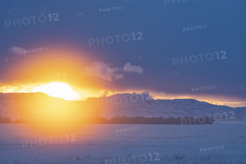 Sun setting over mountains and prairie