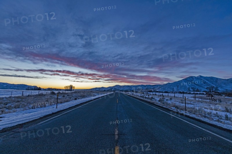 Pink dawn over rural highway and mountains