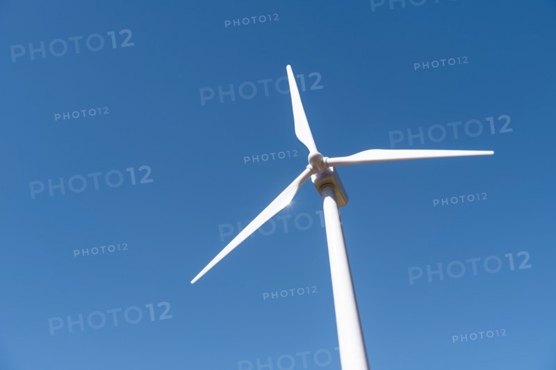 Low angle view of wind turbine against blue sky