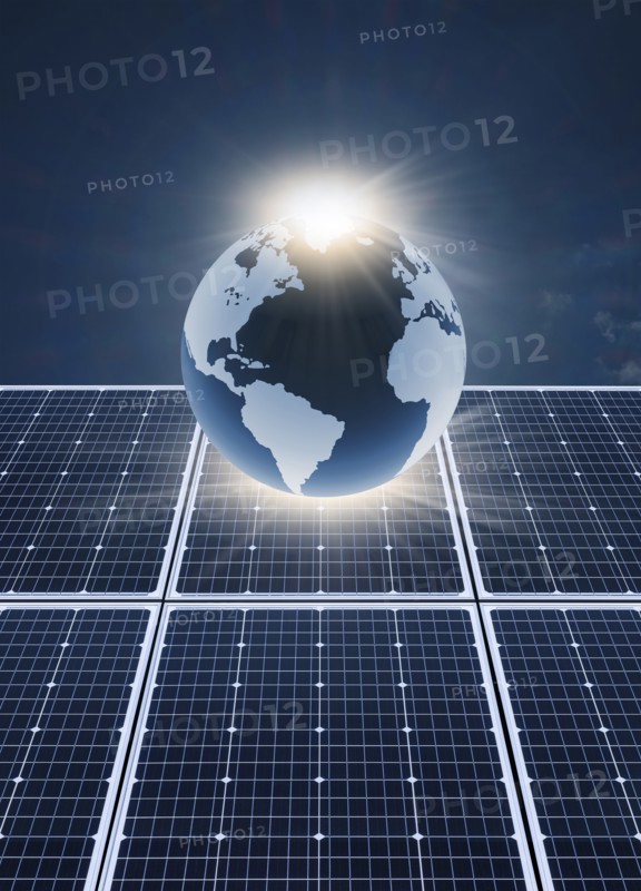 Solar panels and globe against blue sky and sun