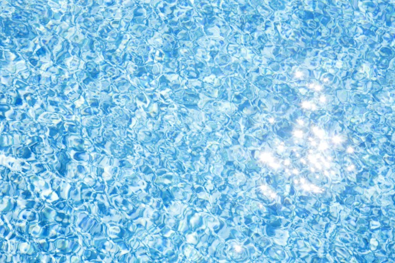 Sparkling reflections of sunlight on pool water surface