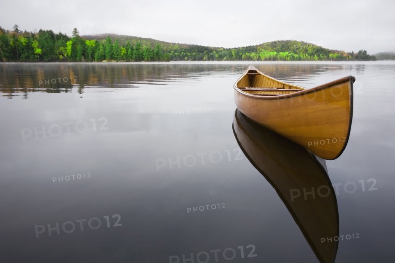 Wooden canoe floating on calm Upper Saranac Lake