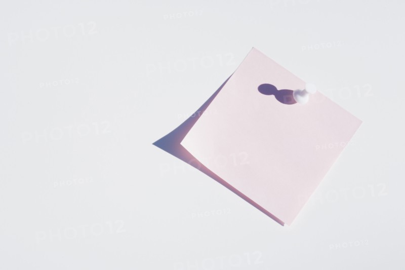 Studio shot of blank pink adhesive post it note