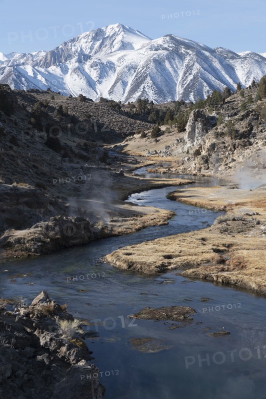 Creek with hot springs with snow covered mountain in background